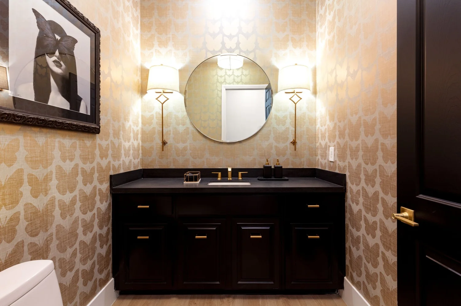 Maison des Papillons powder bath — gold patterned wallpaper and black vanity
