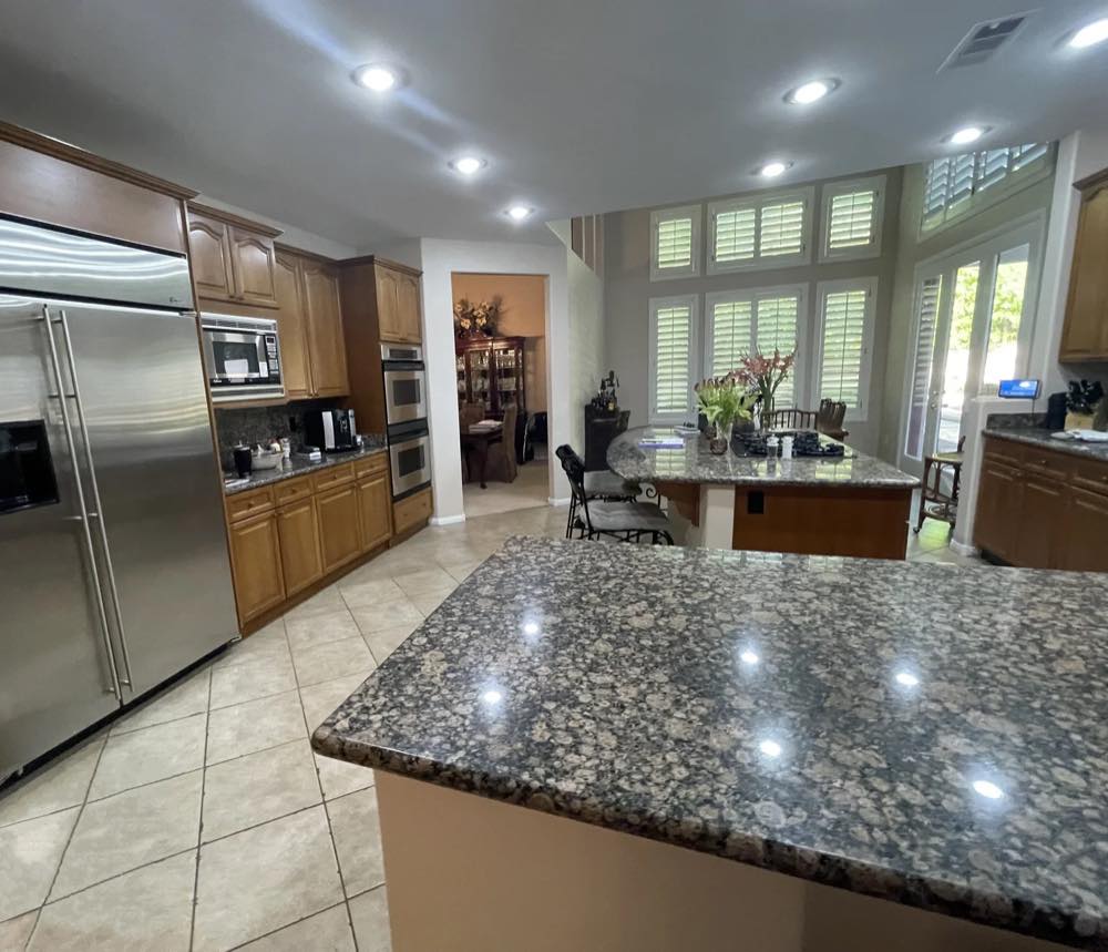Forever Home kitchen before renovation — granite island and tiled floor