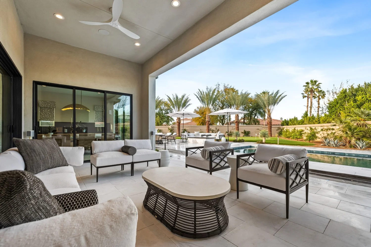 Stone Creek Trail covered patio — outdoor lounge seating facing the pool and palms