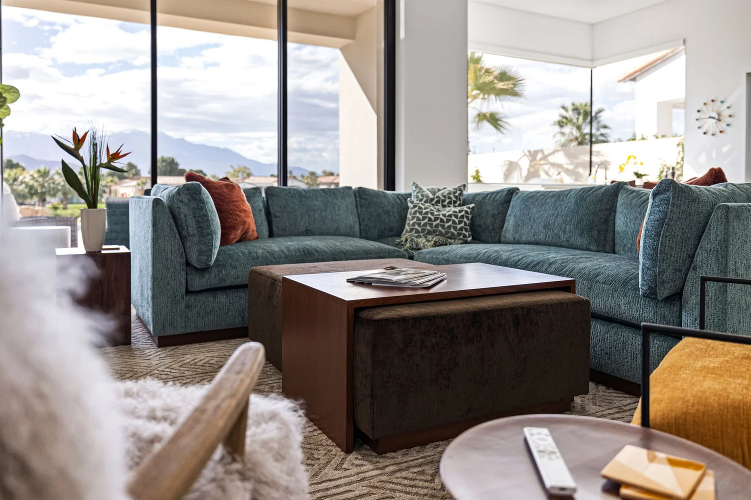 Via Livorno living room — teal sectional against desert mountain views
